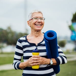 Senior woman with yoga mat and water bottle