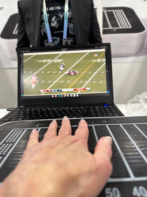 laptop with football game and yard lines on pad