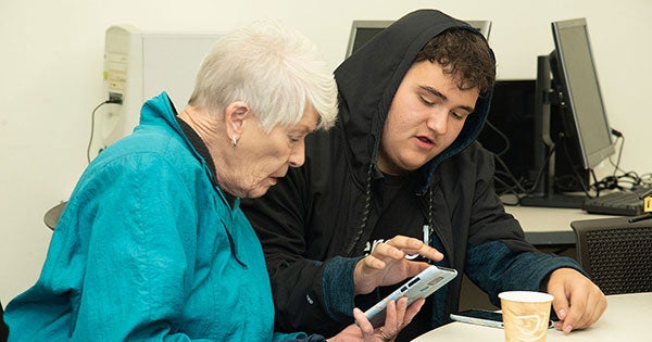older woman and teen looking at smartphone