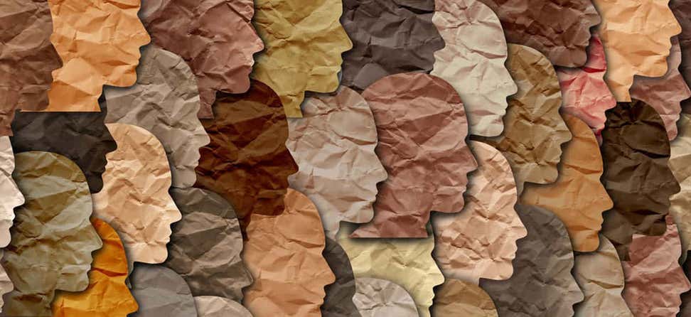 Un primer plano de caras recortadas de papel de todos los colores se apilan una encima de la otra como una obra de arte.