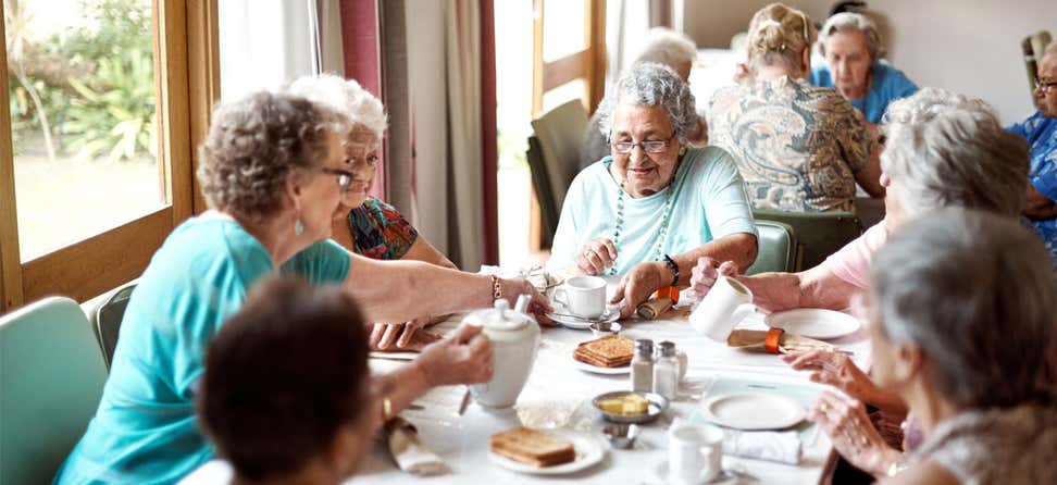 A group of seniors are enjoying their breakfast together in a senior center.