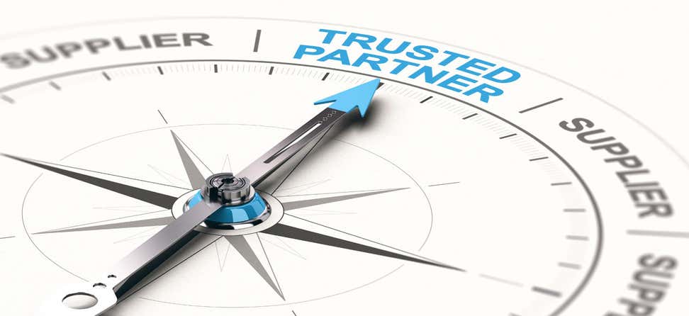 An up-close shot of a compass, where the needle points toward the words "Trusted Partner".