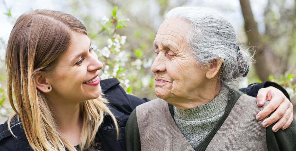 young caregiver with senior woman in park