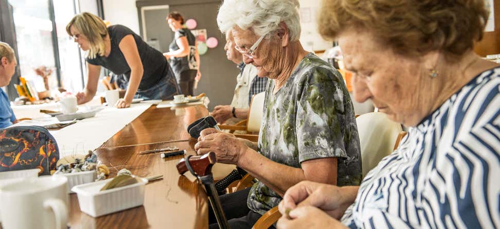  A group of female seniors are doing crafts at a local senior center.