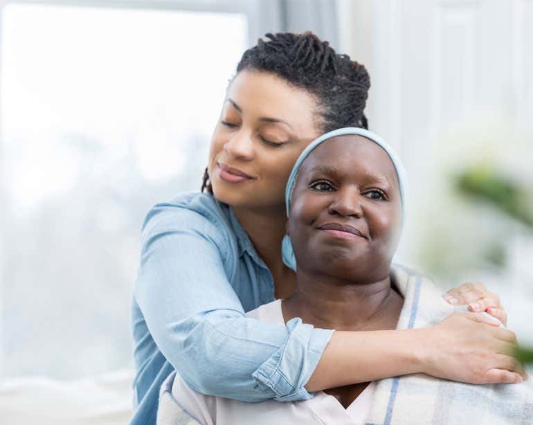 A younger Black female hugs her grandmother in a warm embrace.