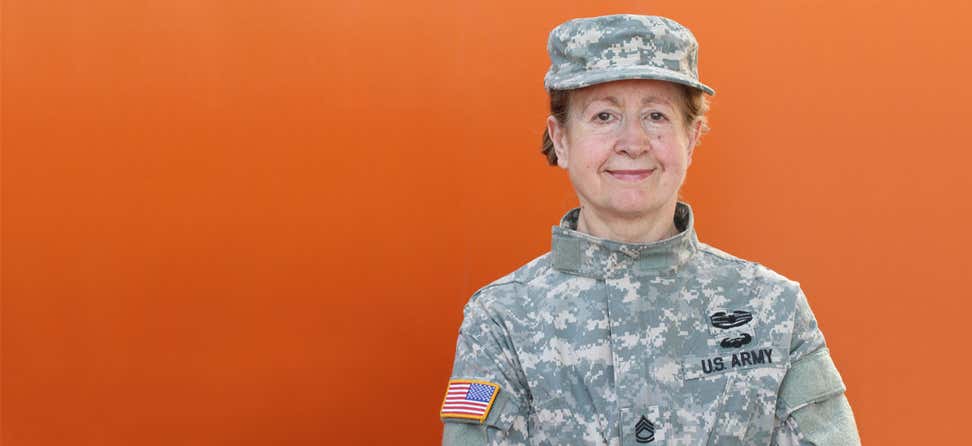 An older female veteran is posing for the camera, smiling.