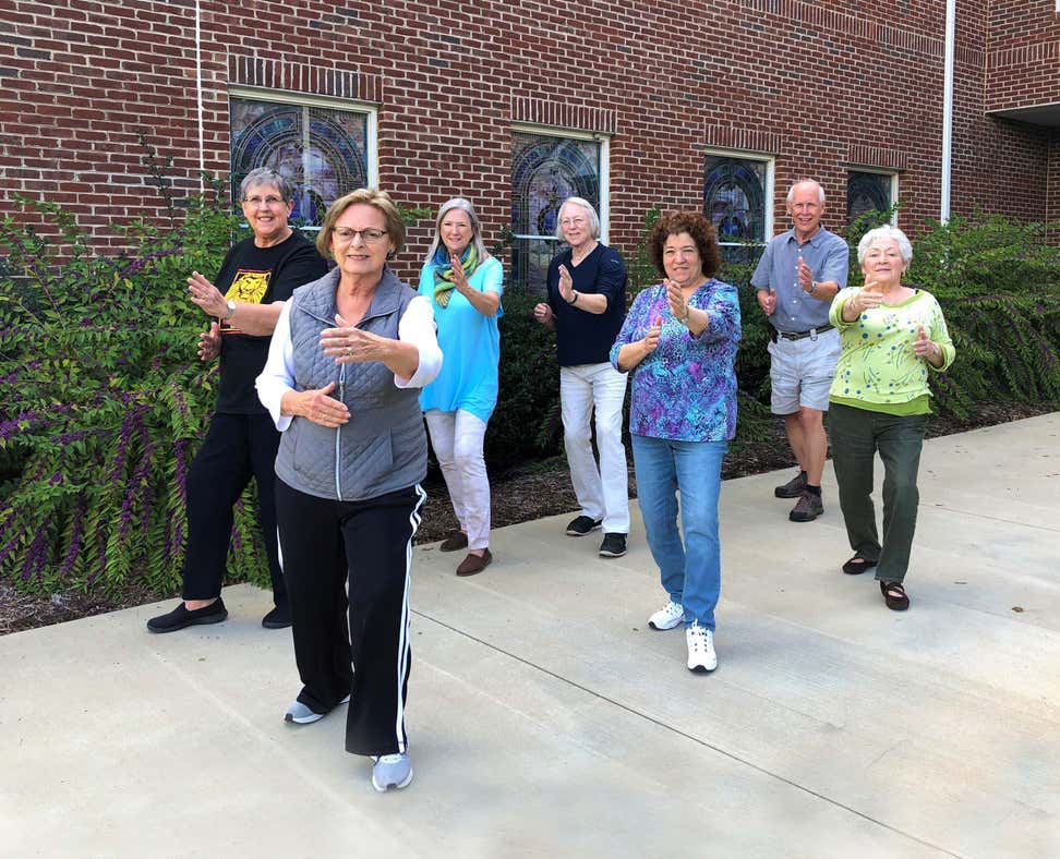 A group of older adults is outside practicing Tai Chi. (Image by Nicole Hiegl)