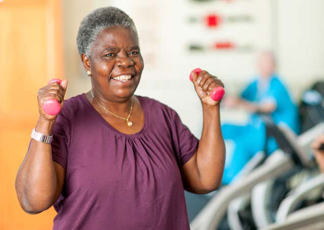 A senior African American woman is working out at gym.