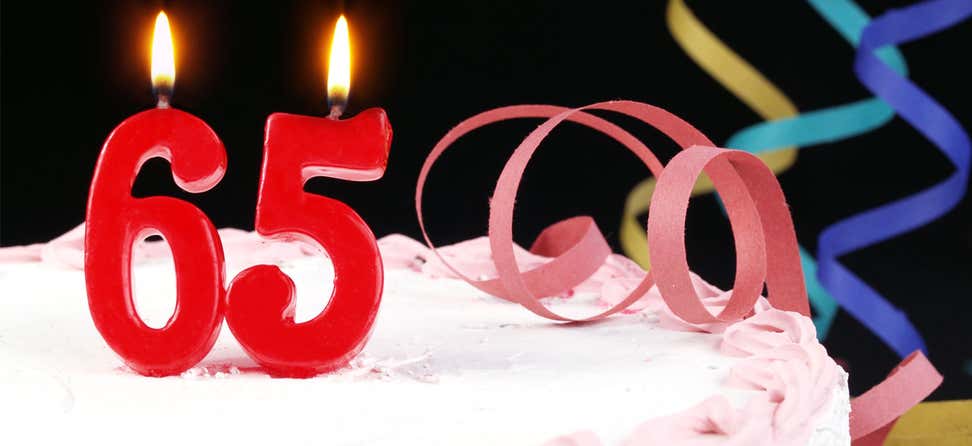 Birthday cake with candles reading 65