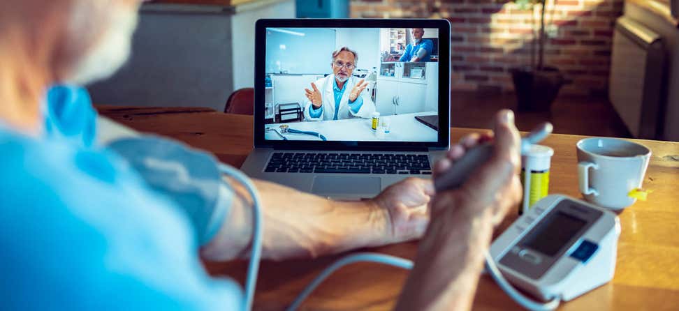 A senior man has a telehealth appointment with his doctor during the pandemic.