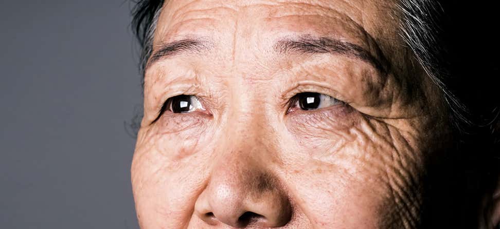 An up close shot of a senior Asian woman's eyes.