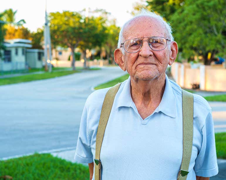 Older man standing on neighborhood street corner
