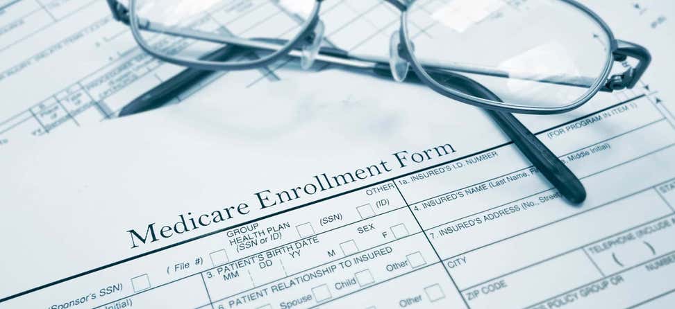 Eyeglasses sit atop a Medicare enrollment form.